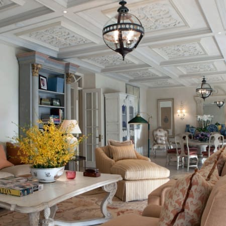 Janine Stone & Co interior design — country house drawing room with bespoke coffered plaster ceiling, antique pendant lanterns and layered traditional furniture, photographed for the Humphrey Munson interview with Janine Stone.