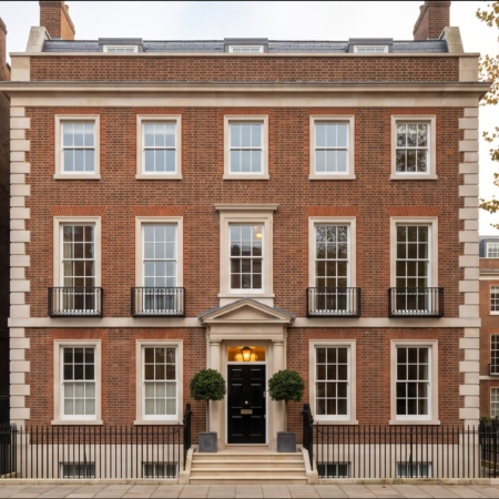 Visualisation: the front of a large red-brick Georgian family townhouse in a London garden square on an autumn morning, with stone steps, black railings and a lit fanlight.